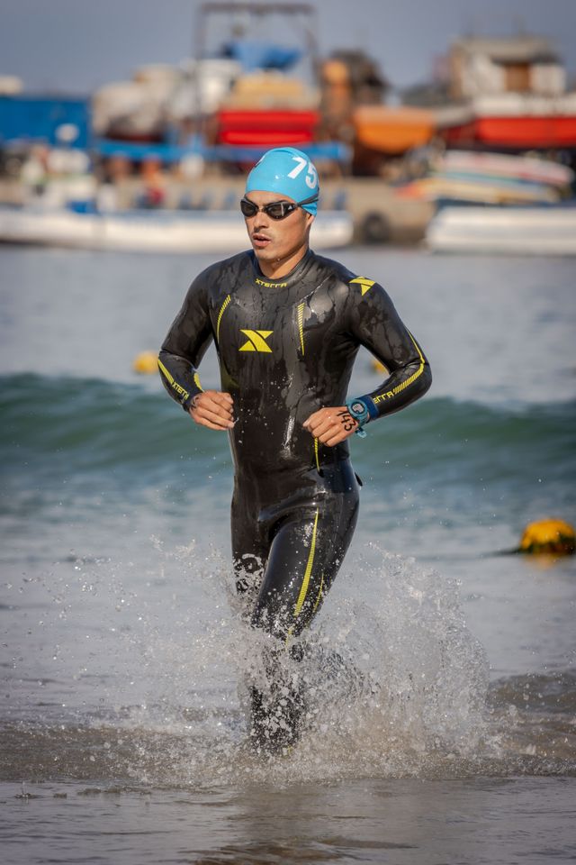 Triatleta esce dall'acqua in muta durante una gara